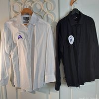 Photo showing white Egyptian cotton slim fit shirt (A) and black Horst cotton-spandex shirt (B) hanging on a door.
