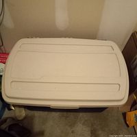 Top view photo showing the closed white lid of the large plastic storage bin.