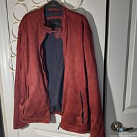 Front view of rust-red suede jacket by Zara showing open front, dual snap button collar, zippered pockets and zippered cuffs.