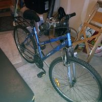 Front and left side angle of the blue Topaz SportChek bicycle showing frame graphics, front suspension, and tires