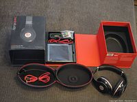 Full lot with headphones, case, cables, adapter, and original packaging laid out on carpeted floor.