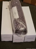 Three boxed rolls labeled WM1500-Foil, WM1500-Wrap, and WM1500-Paper with one roll wrapped in bubble wrap on top.