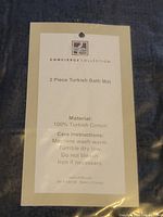 Photo of label showing brand Concierge Collection and material 100% Turkish cotton with care instructions including machine wash warm, tumble dry low, no bleach, iron if necessary.