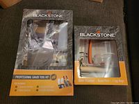 Two boxed sets from Blackstone grill accessory line, showing Professional Grade Tool Kit and Batter Dispenser/Bacon Press/Egg Rings set in unopened packages.