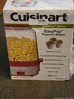 Front view of the unopened Cuisinart EasyPop Popcorn Maker box showing product and key features