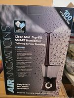 Photo showing the front of the humidifier box with product image and features listed.