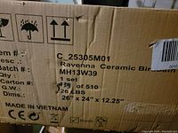 Cardboard box label showing product details including dimensions, weight, and origin (Vietnam)