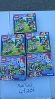 Five new sealed Lego Friends 41120 Adventure Camp Archery boxes arranged on a flat surface showing front packaging with set name, recommended age 6-12, and piece count 114 pcs.