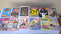 Photo showing 12 assorted comic books including Uncle Scrooge, Star Wars, Saint O, Cracked, Dooms, Agent, Mad Special, Year's Best Photography, Mad Batman, Walt Disney, Richie Rich