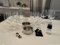 All items from wine glass sets, decanter, stoppers, holder and drip catchers shown on countertop from front angle