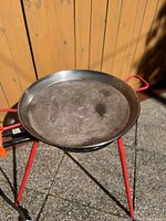 Close-up top view of the 20-inch carbon steel paella pan showing the cooking surface and red handles.