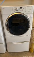 Full front view of Kenmore HE2 dryer mounted on storage pedestal