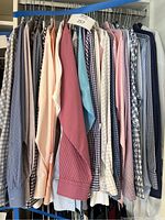 Wide view of men's long sleeve button down shirts in various colors and patterns hung on a rack.
