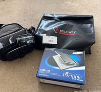 Sony Handycam, Roloway fireproof bag, Samsung DVD player in box on carpeted floor