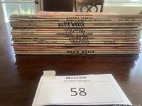 Side stack view of 18 vintage movie magazines from 1950s-1960s with visible titles and dates on spines.