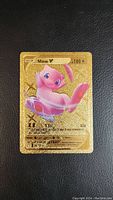 Front of a gold holographic fan art Pokemon card depicting Mew V with stats and moves.