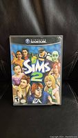 Front cover of The Sims 2 Nintendo GameCube game showing characters and title.
