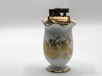 Front side view of vintage Hammersley & Co bone china lighter showing white porcelain with gold floral design and metal lighter top