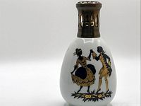 Front view of the vintage Giraud porcelain Lampe Berger oil fragrance lamp showing detailed dancing couple silhouette in black and gold on white porcelain.
