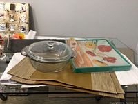 Photo showing all items including leather look placemats, glass casserole dish, glass flowered cake plate with server, and slate serving tray.