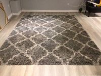 Full view of the rug showing the diamond pattern laid out flat on light-colored floor.