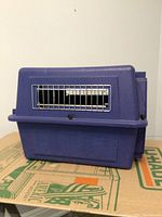 Blue plastic Petmate pet carrier with metal wire grate door. Shows some wear and use.