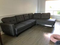Full assembled view of grey sectional sofa with left arm and right chaise in living room