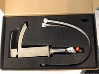 Vigo brushed steel single hole faucet in foam packaging, showing faucet body, handle, braided water supply lines, and mounting hardware.