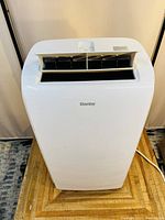 Front upper view showing the air outlet louvers and Danby logo on the white portable air conditioner.