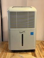 Front view of the Forest Air dehumidifier showing brand logo, air vent grille, and water level indicator.