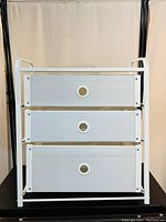 Front view of the IKEA LOTE 3-drawer chest showing white semi-transparent drawer fronts with circular finger holes.