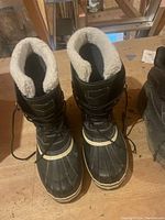 Pair of black men's winter boots with white fleece lining and rubber soles.