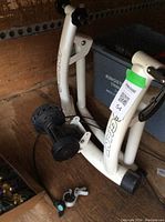 White metal indoor bike trainer stand marked 'GIANT', showing the resistance roller and tension adjustment cable attached to a lever.