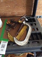 5 various C clamps on a black surface, showing different sizes and designs.