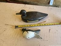 Top view showing both duck decoys with measuring tape indicating size