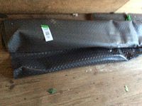 Rolled black rubber flooring mat with diamond plate texture on wooden floor.