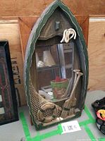 Close-up of canoe-shaped mirror with nautical decorations and inset rectangular mirror