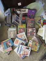 Stack of CDs and DVDs showing various artists including Run DMC, Our Lady Peace, Elton John and others