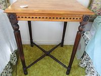 Front view showing the carved legs with decorative rosettes and the smooth wood top edge.