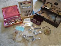 Wide view showing multiple jewelry boxes with assorted vintage jewelry, watches, buttons, and stamps.