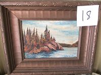 Frontal view of the framed oil painting showing landscape with rocky coast, pines, water, and sky. Signature 'O. Herriott 38' visible bottom right.