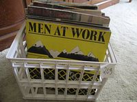 Records in a white plastic crate showing the front Men at Work LP and other records behind it