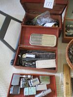Three wooden boxes each containing assorted vintage items including lighters, scissors, and a straight razor.