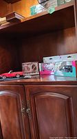 Wide view showing all items on wooden shelf including 1965 Mercedes 230SL model, boxed die cast cars, and Jubilee mug with coaster in box.