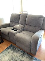 Front angle view showing grey upholstery and center cup holders