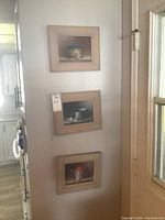 Three framed still life paintings hung on wall