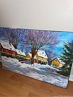 Full view of the winter scene painting on canvas showing houses, large tree, and snow landscape.