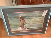 Framed watercolor painting showing the full artwork titled 'Sisters on Beach' by June Fortin, in good condition with a blue frame and matte.