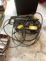 Photo of the Karcher pressure washer unit showing front and attached hoses and wand coiled around it on the floor.