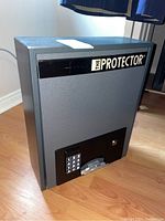 Front and side view of gray metal safe showing digital keypad and brand label